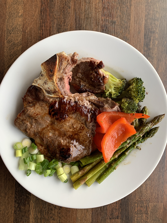 Steak dinner with asparagus, red pepper, green onion and broccoli